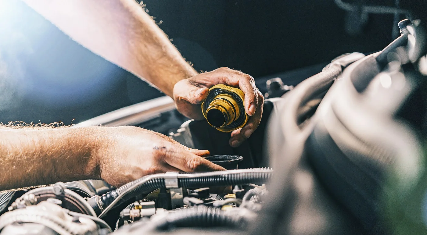A technician performing an oil change on a Ford truck